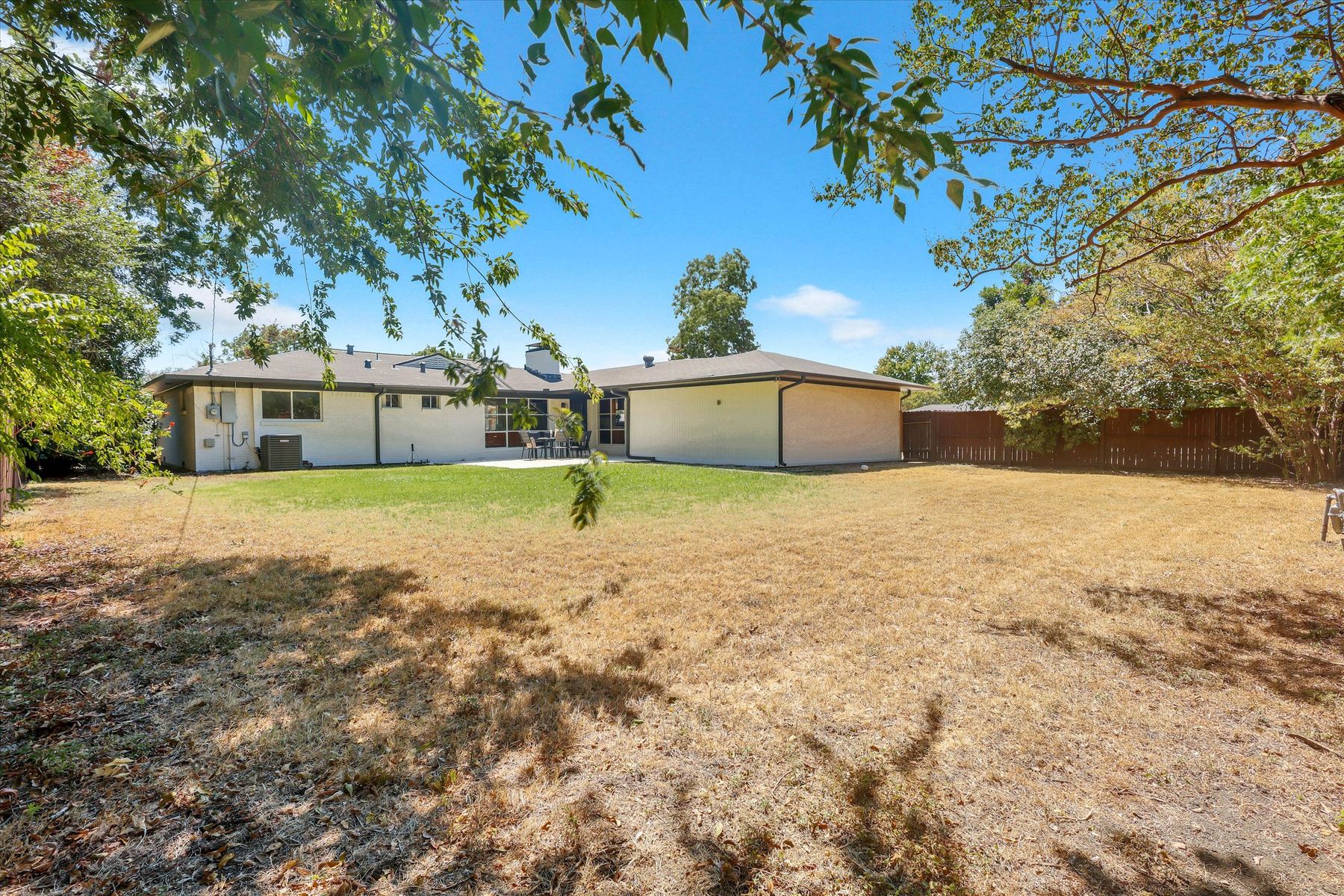 The back yard at 3303 Lockmoor Lane, looking across the lawn toward the house and rear patio