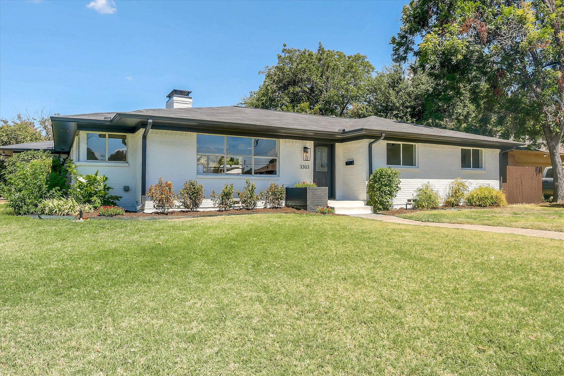 Front elevation of 3303 Lockmoor Lane, a white painted brick single story home
