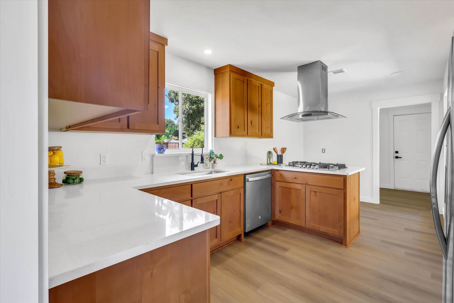 Kitchen with quartz counters, gas cooktop, and island vent hood