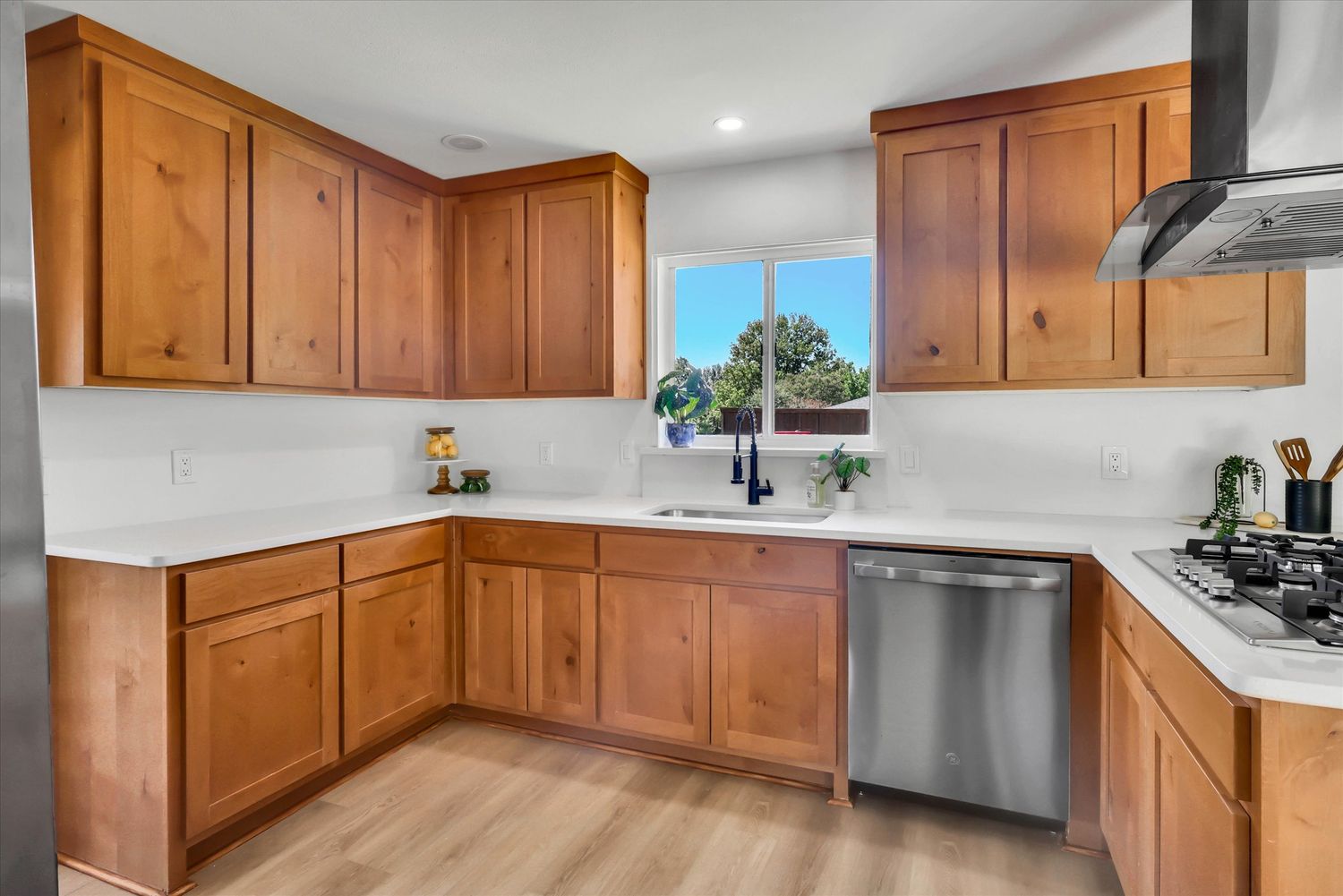 Kitchen with sink window, dishwasher, and wood shaker cabinetry