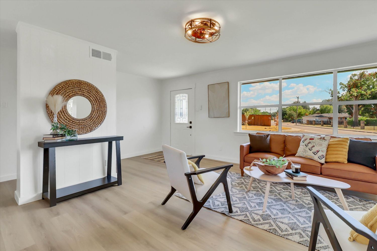 Wide view across two living areas toward the fireplace and built ins