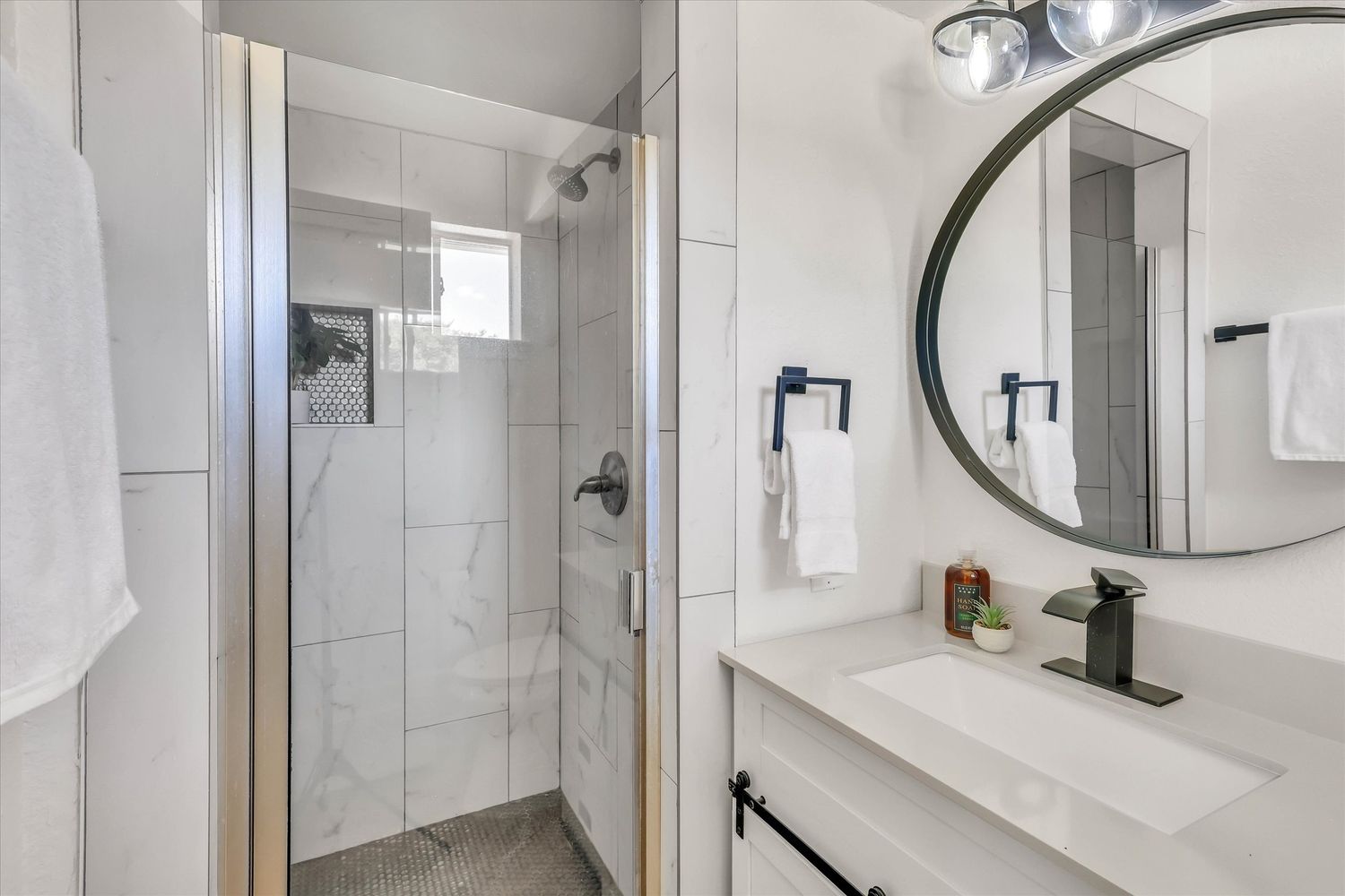 Second bath with tiled walk in shower and white vanity