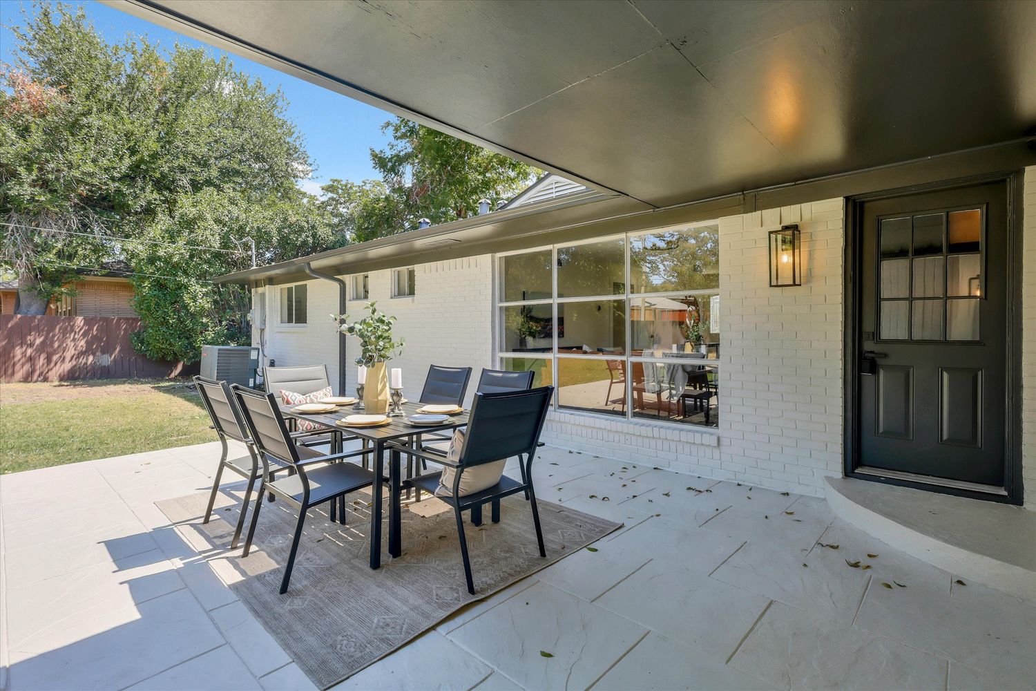 Stamped stone patio running the width of the rear elevation under a deep roof overhang